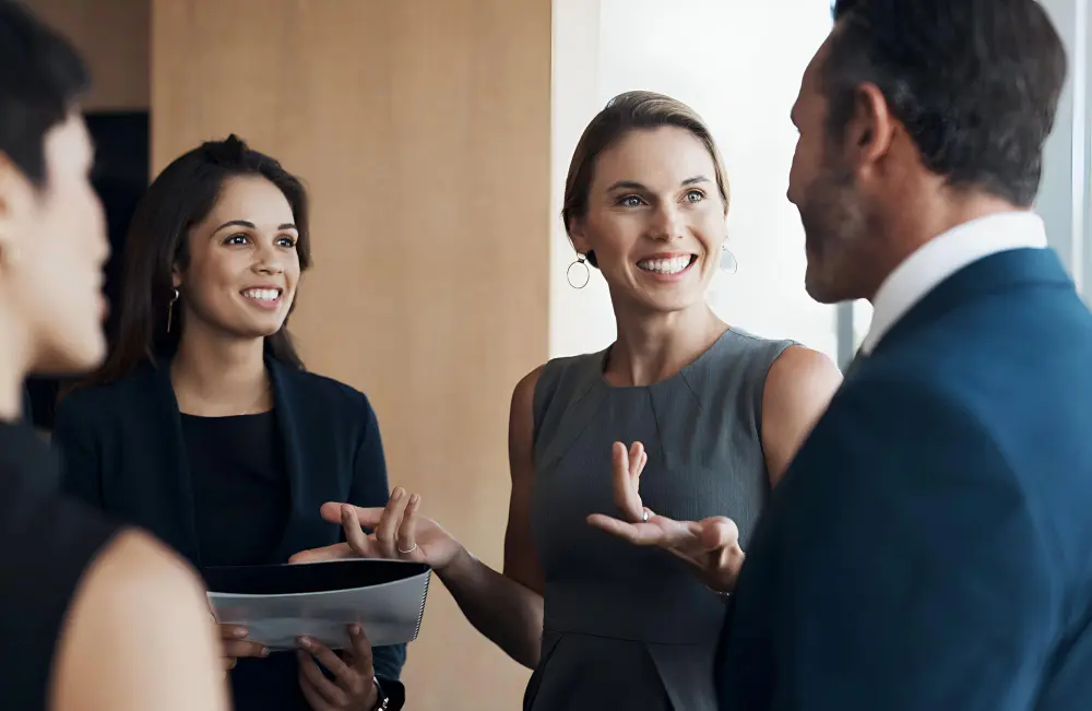 deux femmes souriantes qui échangent avec deux personnes